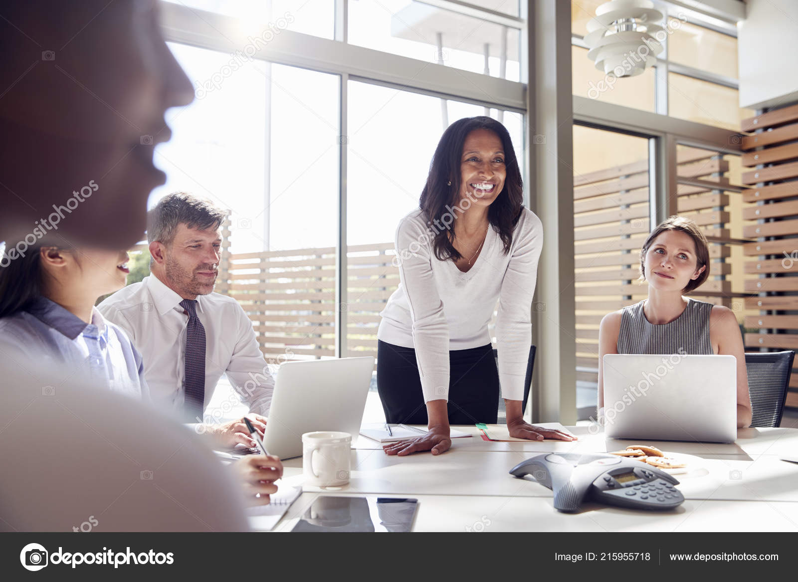 Smiling female manager listening to colleagues at a meeting
